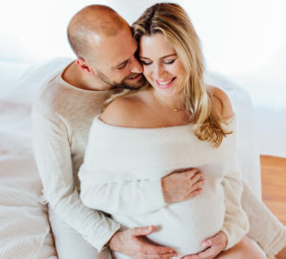 Zwangerschapsfoto koppel Utrecht op bed thuis hoogzwanger witte trui